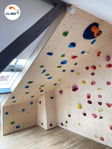 Mur d'escalade pour enfants et adultes sous combles construit par CLIMB IT dans une maison privée. Prises d'escalade pour tous niveaux