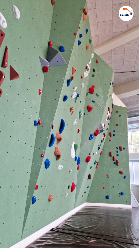 Mur d'escalade intérieur 150m2 en entreprise par CLIMB IT avec dévers progressif en bloc