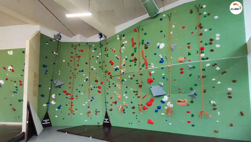 Mur d'escalade intérieur 150m2 en entreprise par CLIMB IT avec 8 couloirs de grimpe sur cordes et enrouleurs